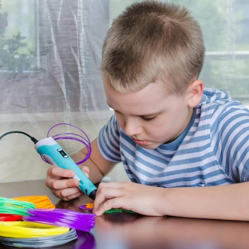 Boy creating a model with a 3D pen
