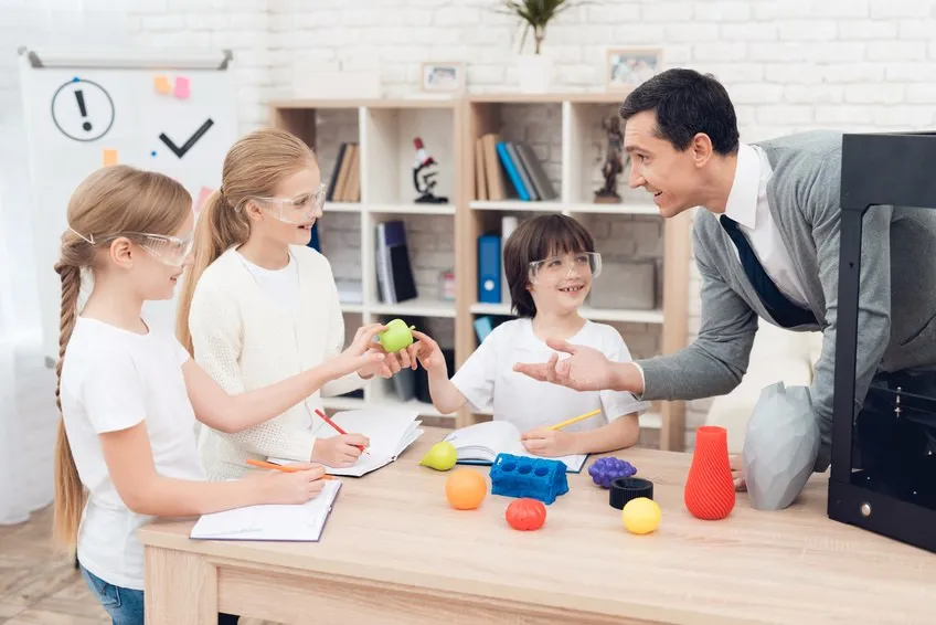 Teacher showing 3D printed shapes to pupils
